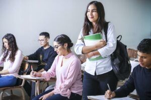 studentka idąca przez klasę z podręcznikami w ręce